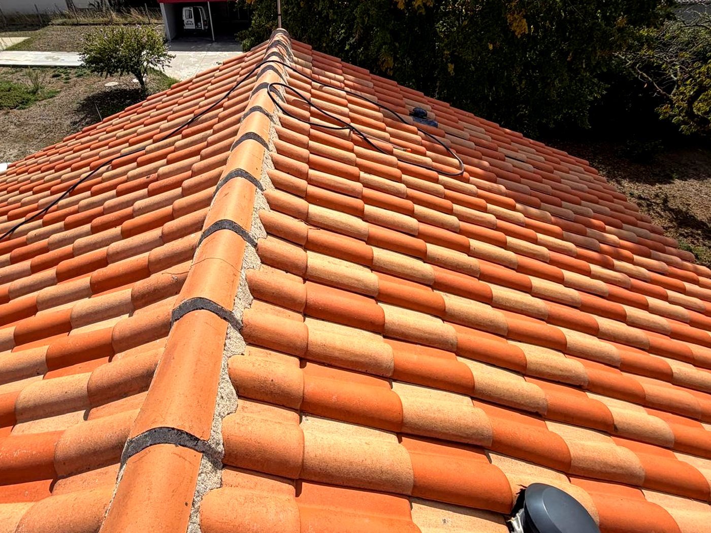 Toiture en tuiles orange nettoyées, chantier en Charente